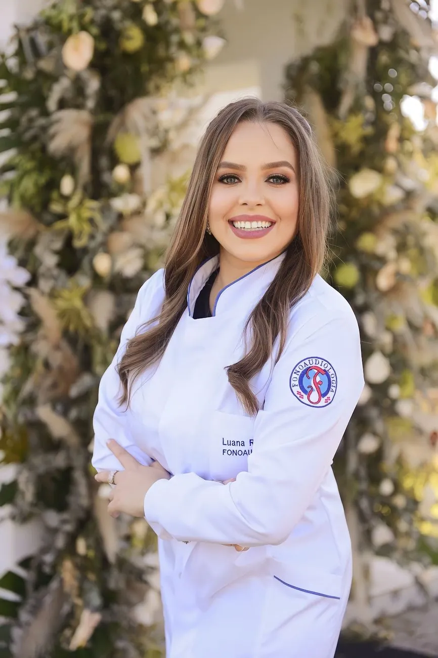 Fonoaudióloga Luana Rech Posso sorrindo, de jaleco